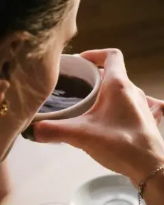 Pessoa bebendo café sob uma luz suave